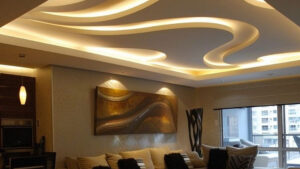 Modern living room featuring a stylish false ceiling with curved LED cove lighting, showcasing elegant ceiling design ideas for contemporary home interiors.