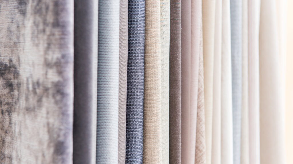 Close-up of premium curtain fabric samples showcasing various textures and neutral shades, perfect for modern curtain design ideas and stylish home interior décor.