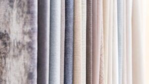 Close-up of premium curtain fabric samples showcasing various textures and neutral shades, perfect for modern curtain design ideas and stylish home interior décor.