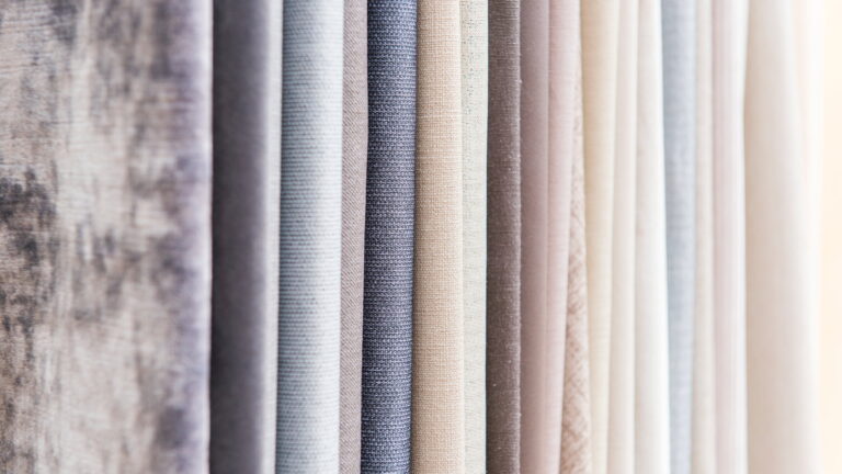 Close-up of premium curtain fabric samples showcasing various textures and neutral shades, perfect for modern curtain design ideas and stylish home interior décor.